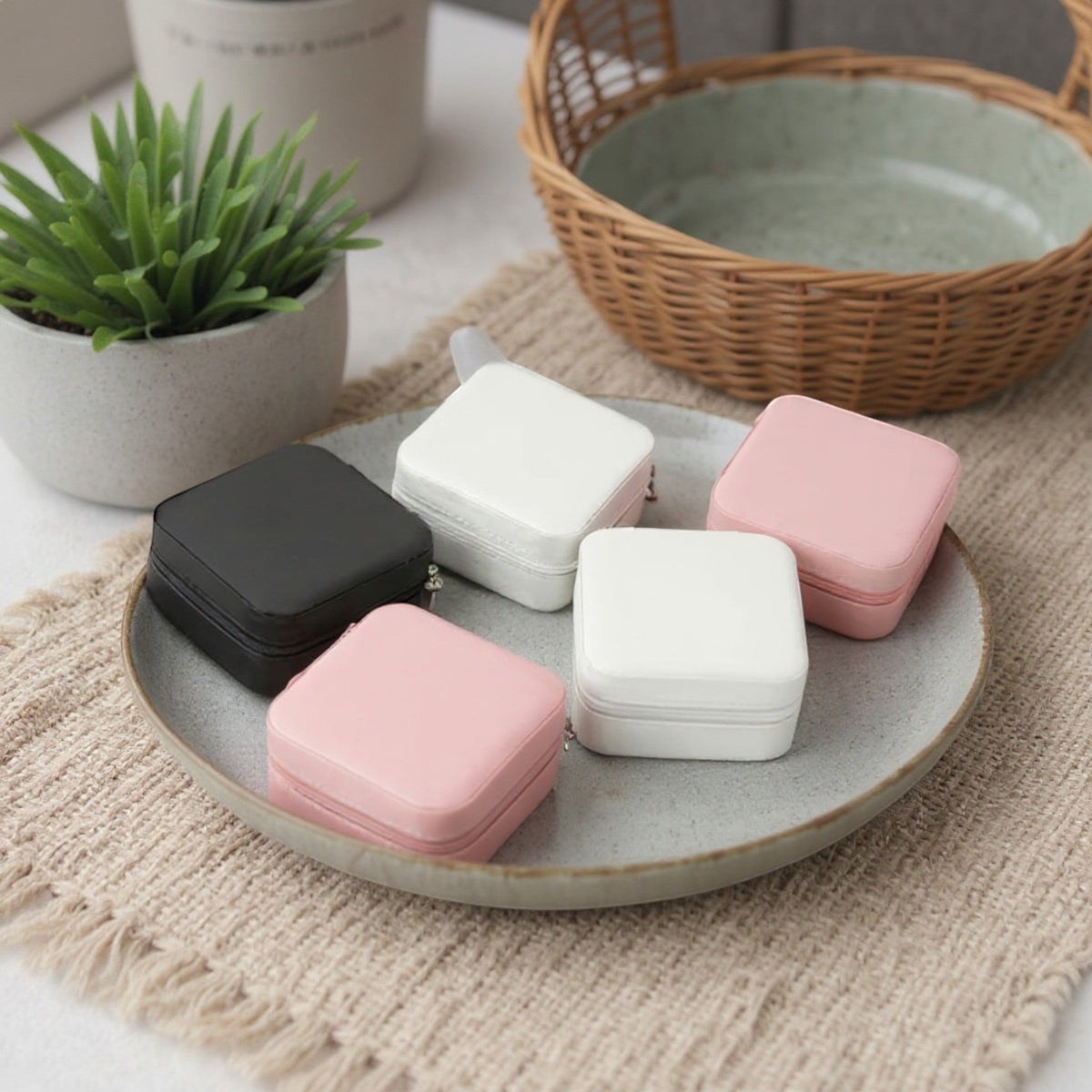Boîtes à bijoux carrées en velours, posées sur un plateau avec un intérieur décoratif et un style minimaliste.
