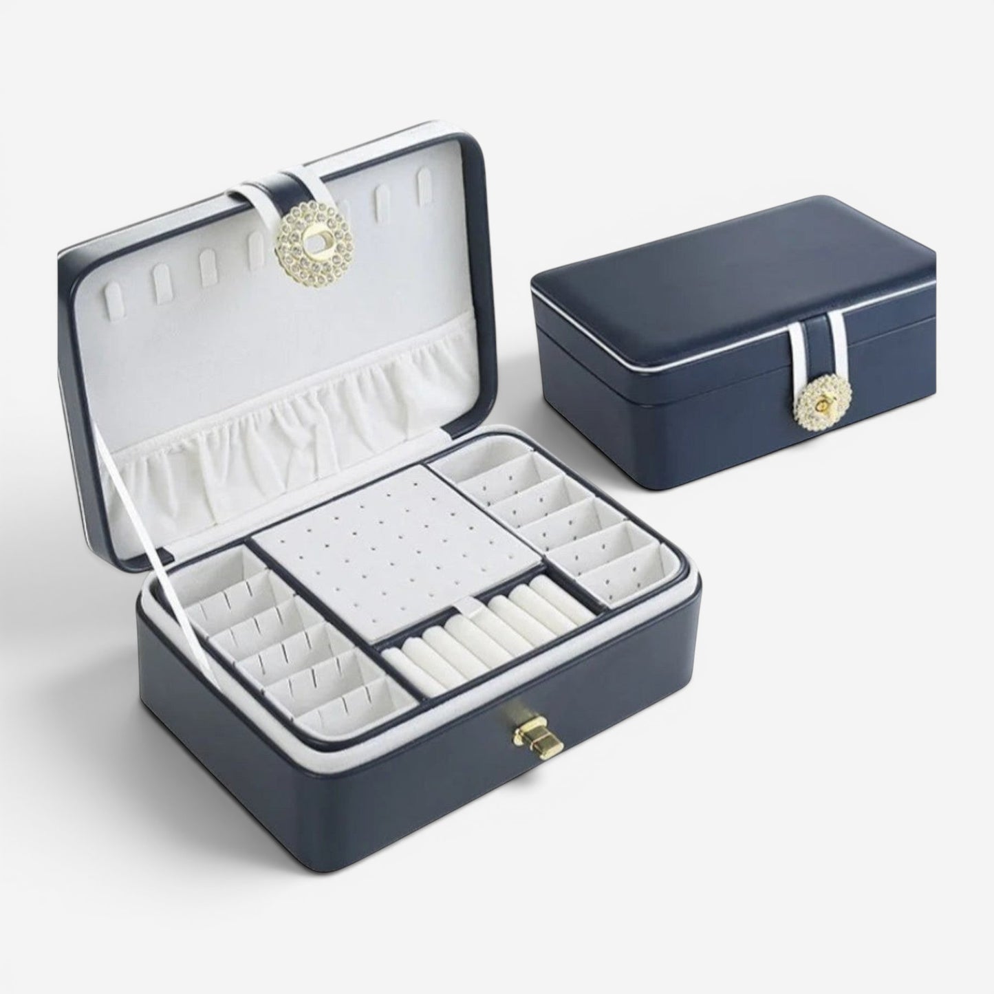 Boîte à bijoux ouverte avec nombreux compartiments, coussins pour bagues et espace pour colliers.