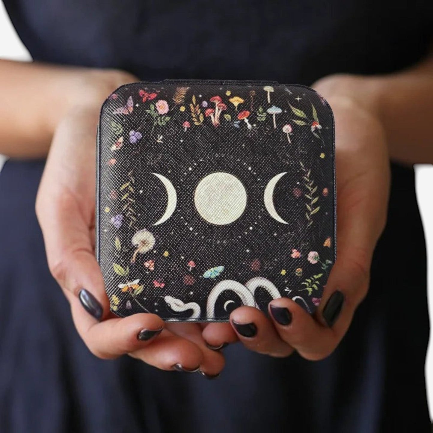 boîte à bijoux lune au design noir décoratif tenue en main avec motifs élégants