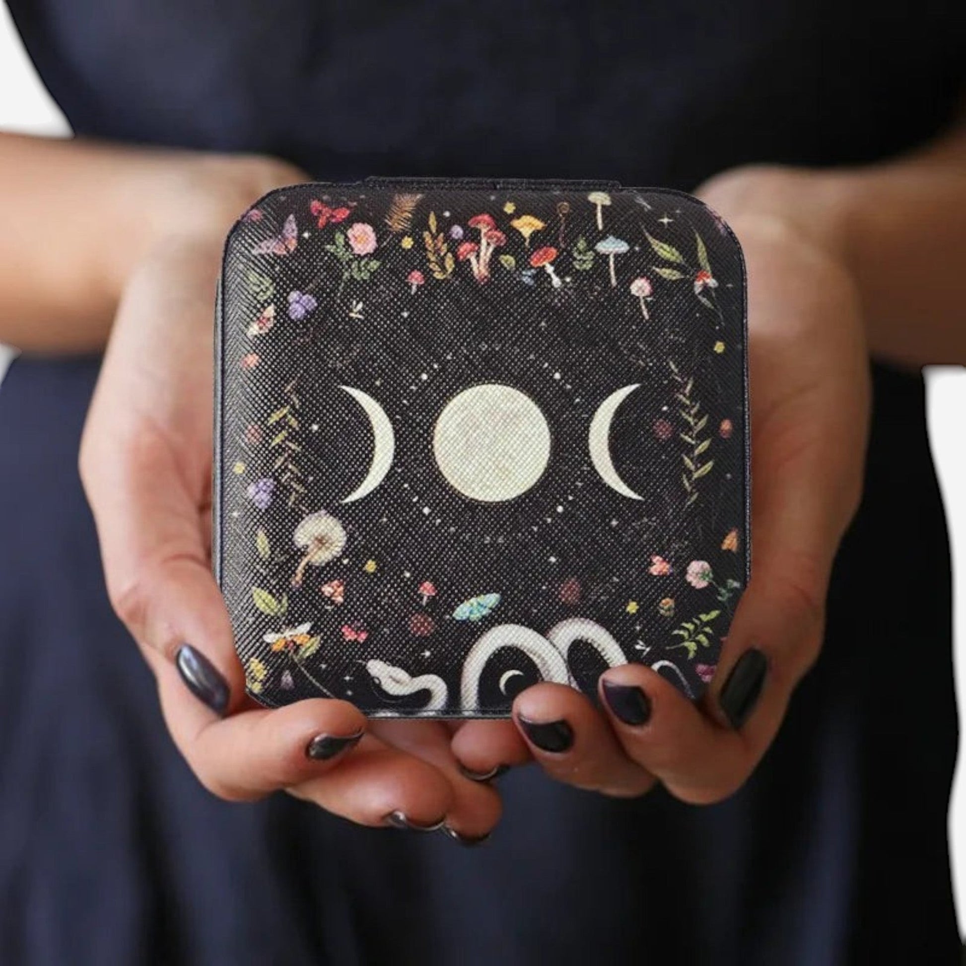 boîte à bijoux lune au design noir décoratif tenue en main avec motifs élégants
