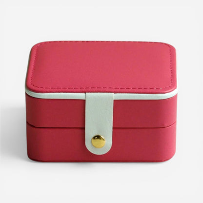 Boîte à bijoux rouge, fermée avec bouton doré et finition élégante.