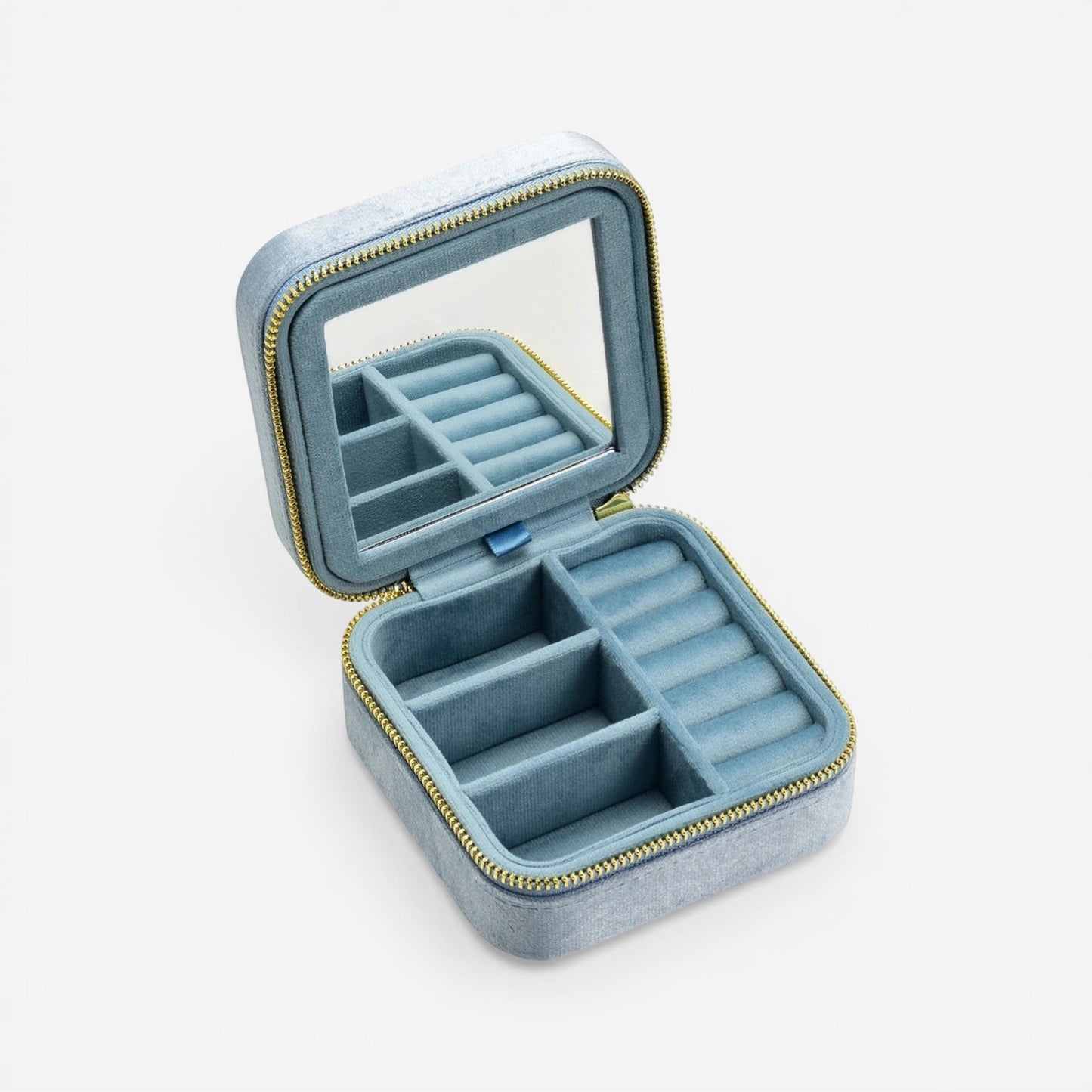 Boîte à bijoux carrée en velours bleu ciel, ouverte avec miroir et rangement pour bagues et accessoires.