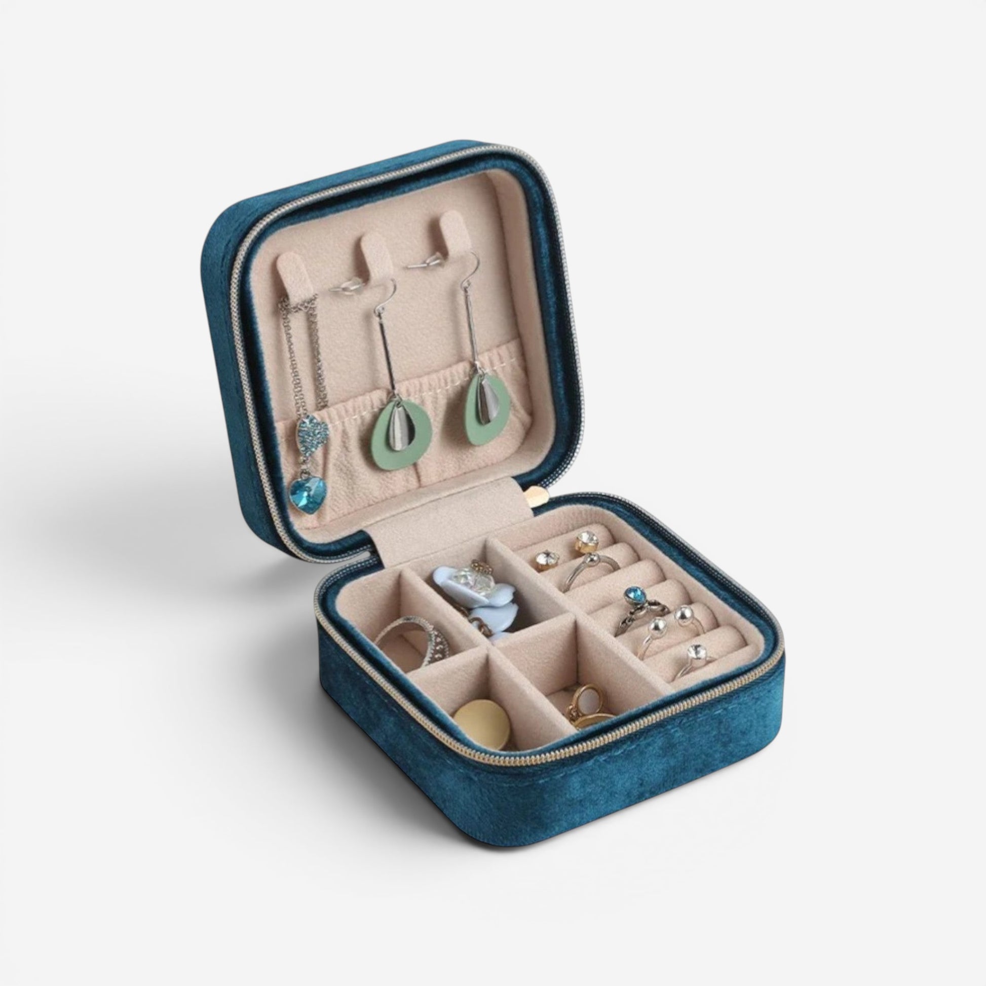 Boîte à bijoux en velours bleu, ouverte avec compartiments et bijoux organisés.