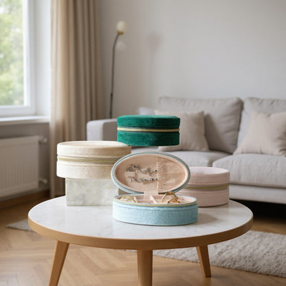 Boite a bijoux ovale en velours, posée sur une table basse, avec rangement de bijoux dans un intérieur de salon.