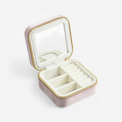 Boîte à bijoux carrée en velours rose et blanc, ouverte avec miroir et rangements pour bijoux.