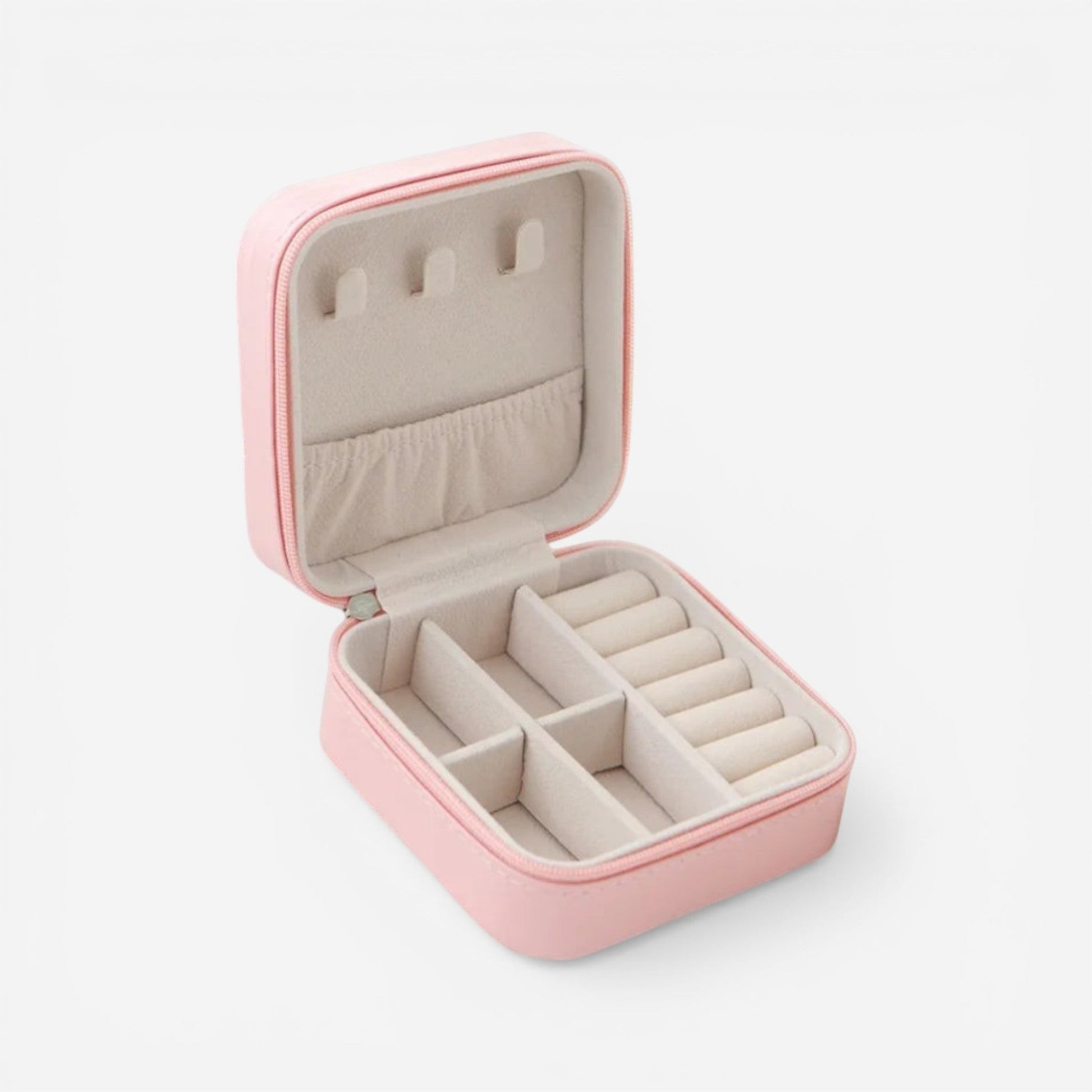 Boîte à bijoux carrée en velours rose, ouverte avec compartiments pour bagues et accessoires.