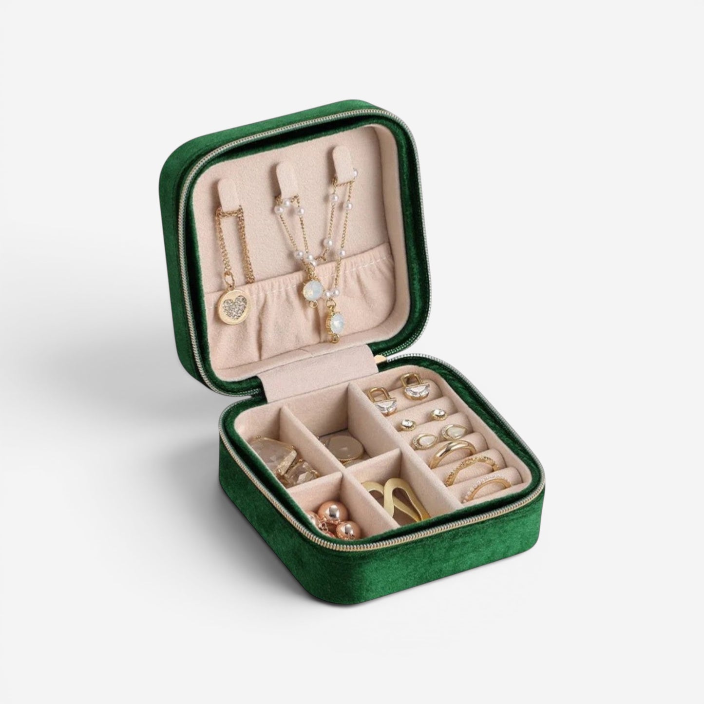 Boîte à bijoux en velours vert, ouverte avec bijoux et compartiments bien organisés.