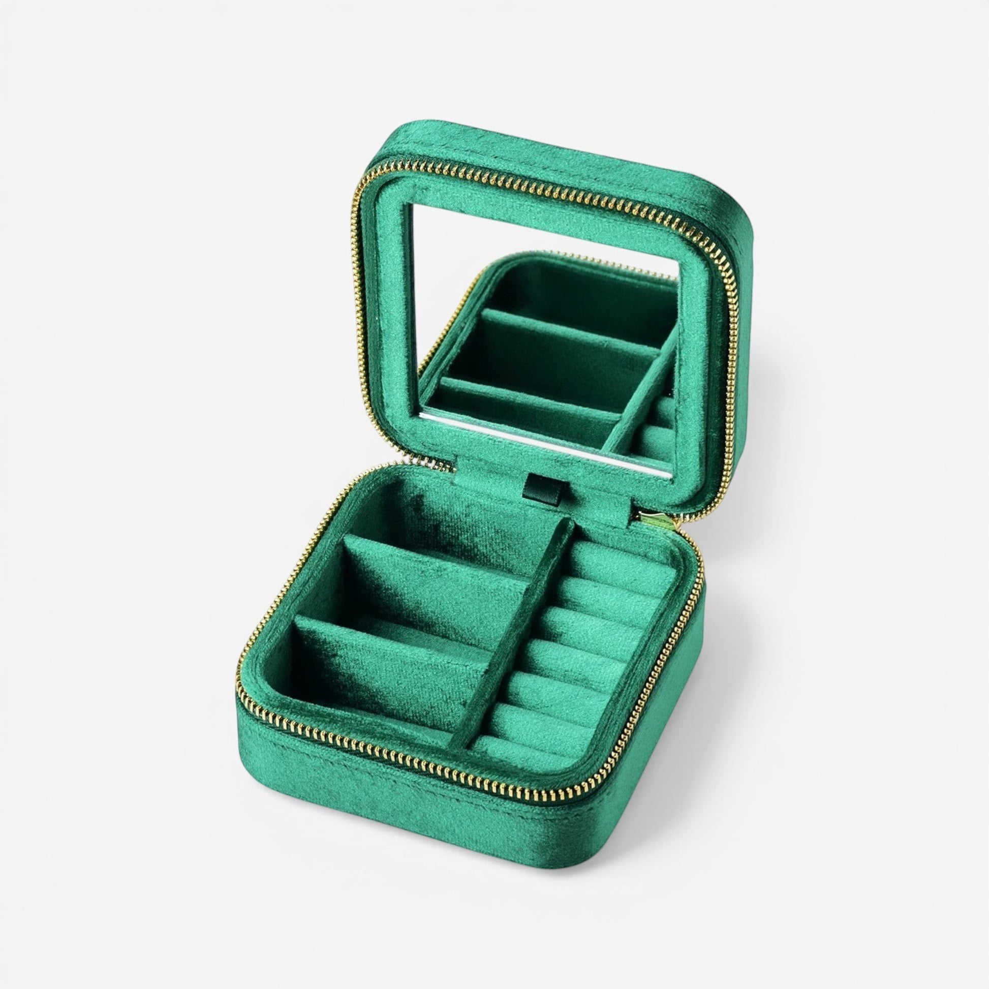 Boîte à bijoux carrée en velours vert émeraude, ouverte avec miroir et compartiments pour bagues et accessoires.