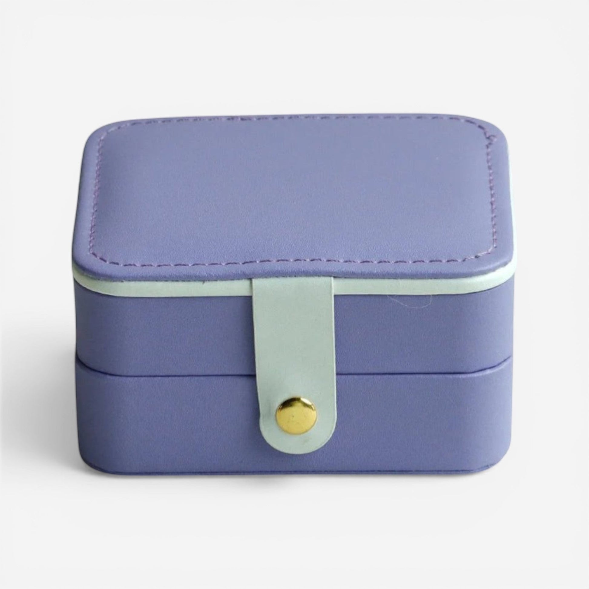 Boîte à bijoux violette, fermée avec bouton doré et finition douce.