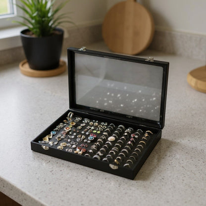 Boîte à bijoux design en cuir noir avec couvercle en verre transparent, parfaite pour exposer les bijoux.