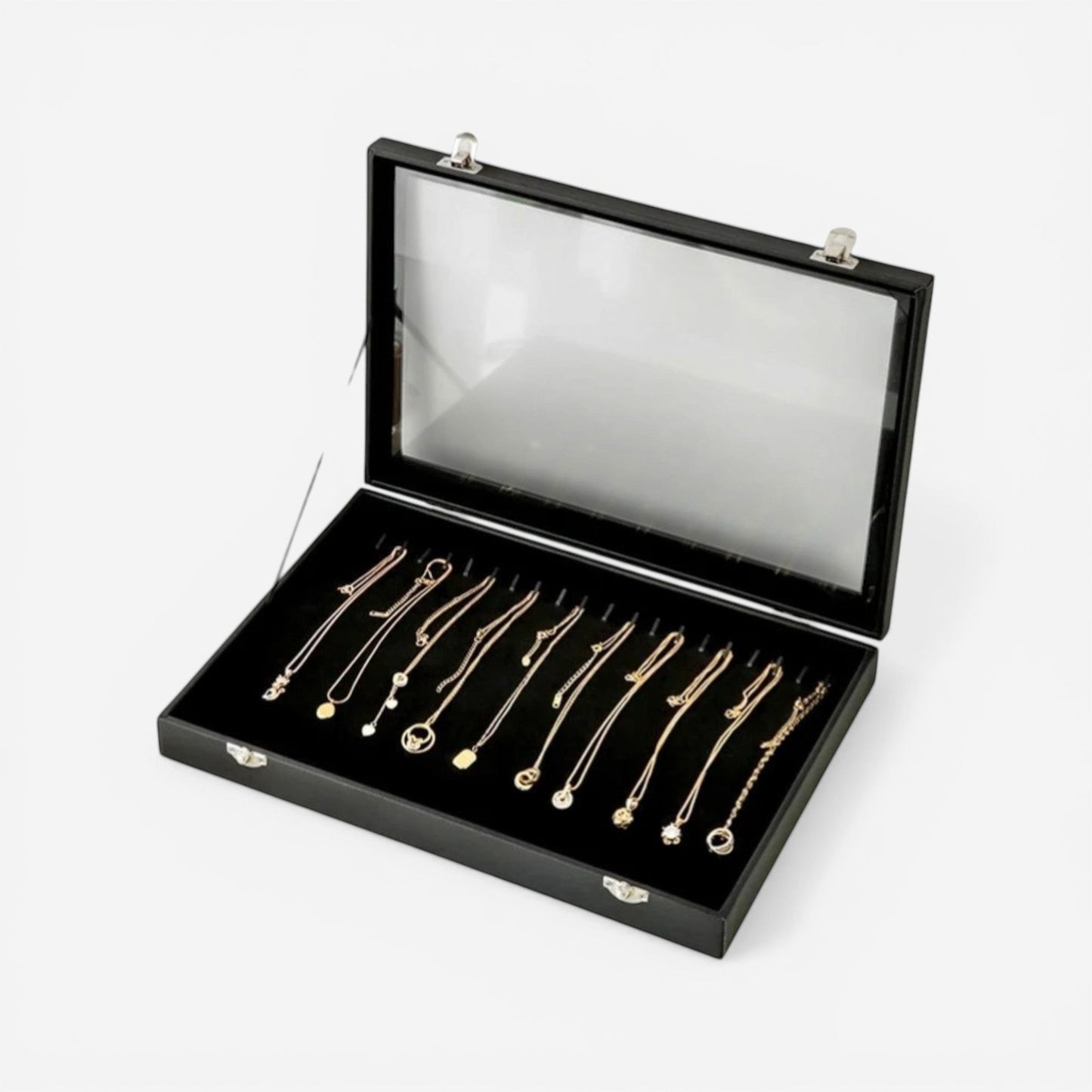 Boîte à bijoux en cuir noir avec vitre transparente ouverte, présentant les compartiments pour bagues et accessoires.