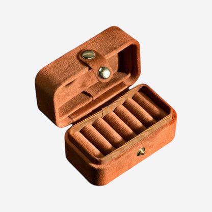 Boîte à bijoux de voyage en velours marron, compacte, avec compartiments pour organiser les bijoux.