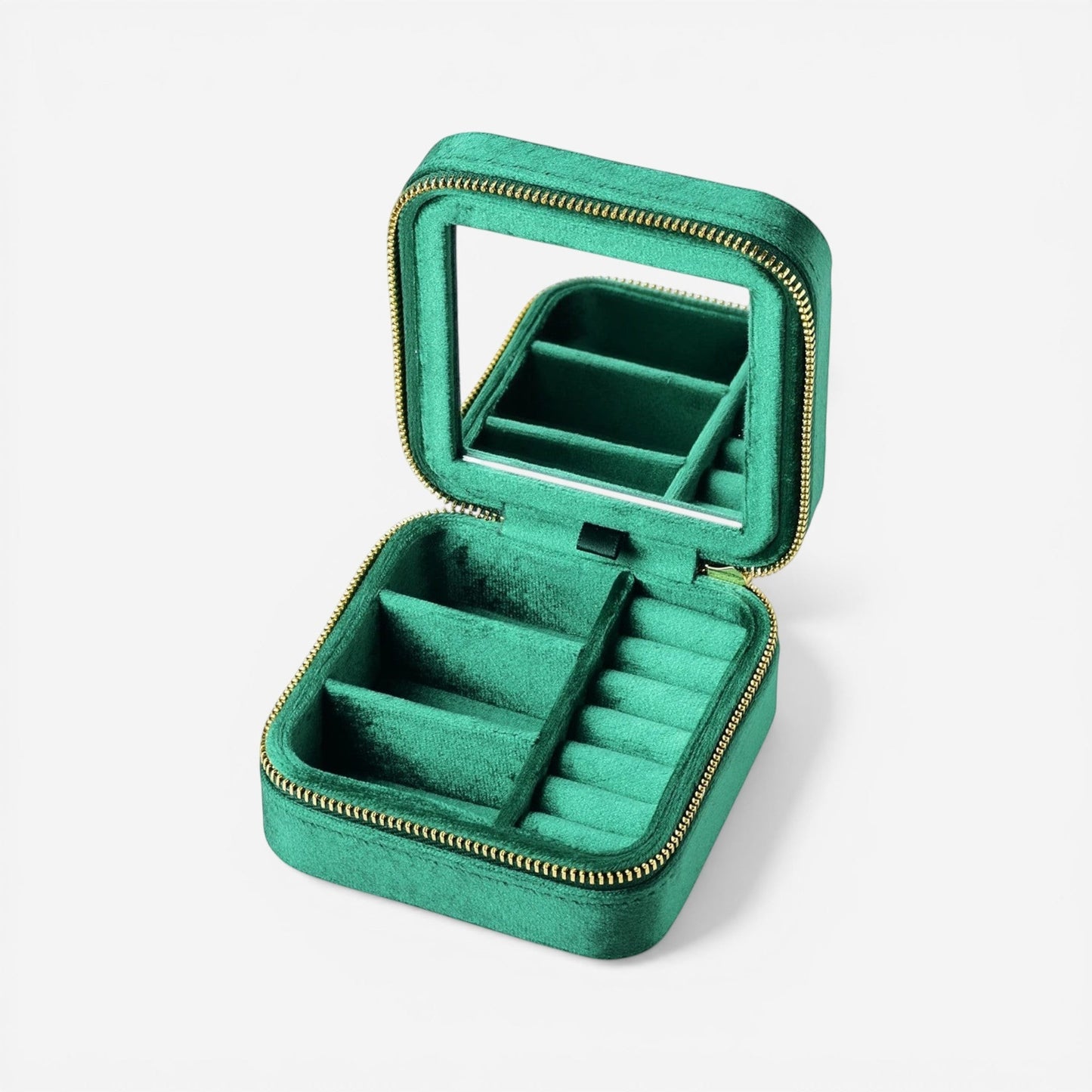 Boîte à bijoux de voyage en velours vert compacte avec compartiments pour bagues et colliers, idéale pour les déplacements.