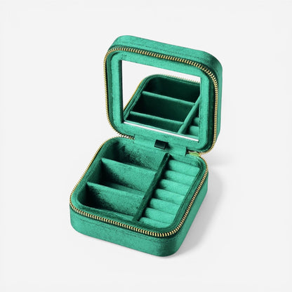 Boîte à bijoux de voyage en velours vert compacte avec compartiments pour bagues et colliers, idéale pour les déplacements.
