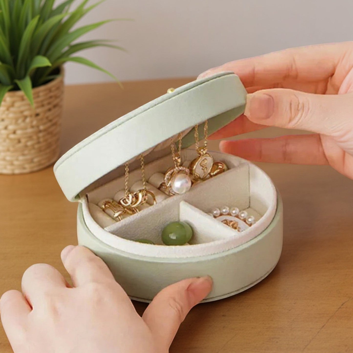 Boîte à bijoux de voyage en cuir PU vert sauge, ouverte, avec compartiments pour bagues et colliers.