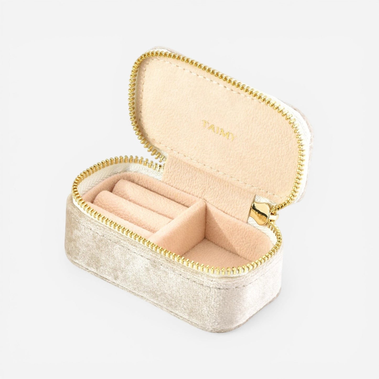 Mini boîte à bijoux en velours beige clair ouverte avec compartiments pour organiser bijoux et bagues.