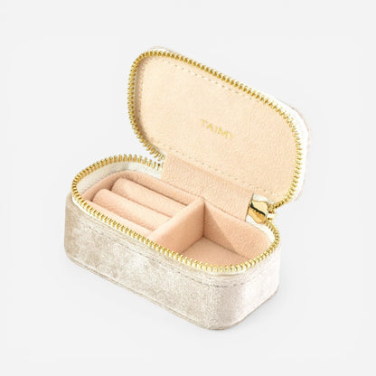 Mini boîte à bijoux en velours beige clair ouverte avec compartiments pour organiser bijoux et bagues.
