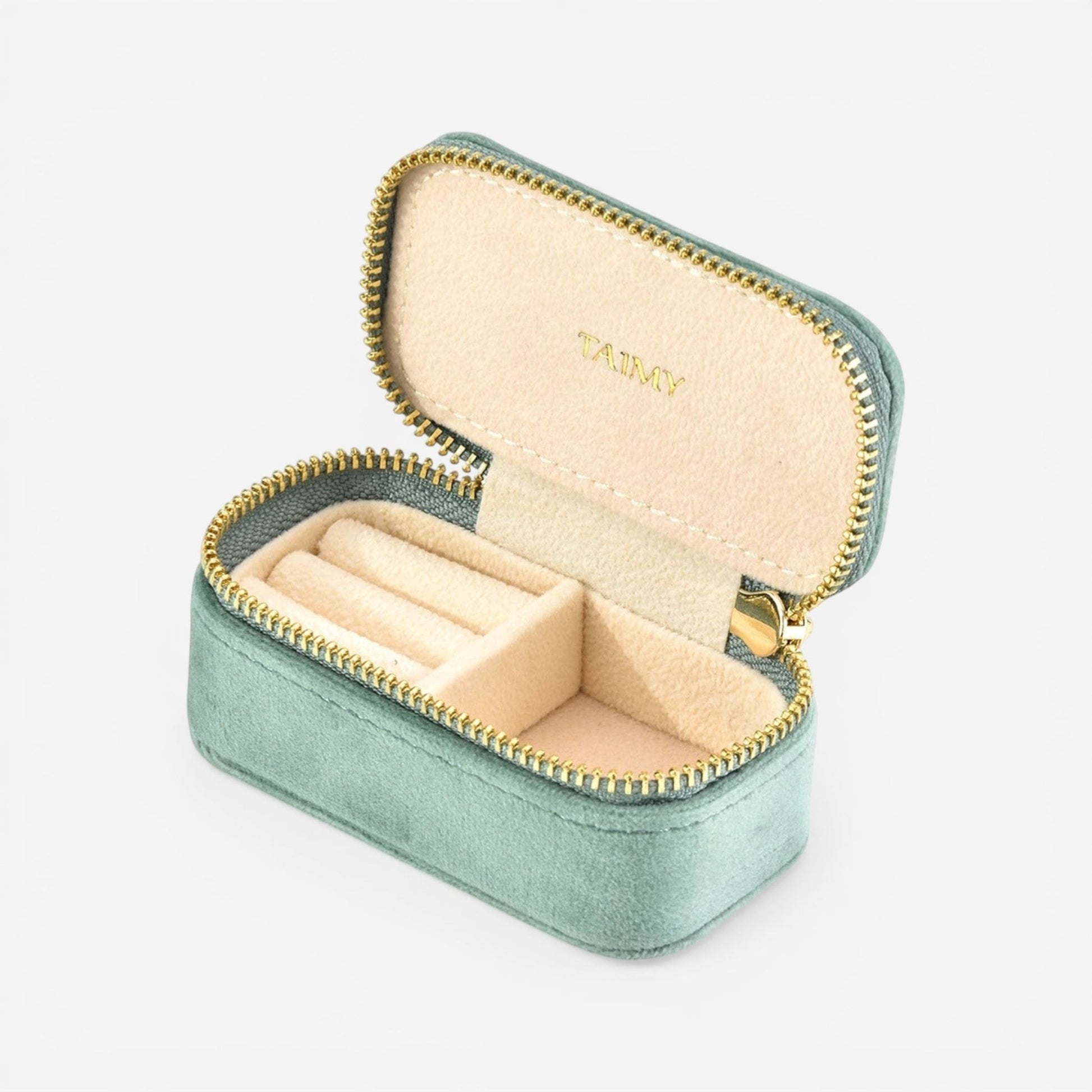 Mini boîte à bijoux en velours vert clair ouverte avec compartiments pour organiser bijoux et bagues.