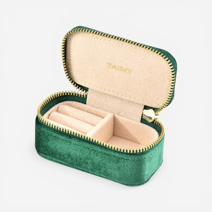 Mini boîte à bijoux en velours vert foncé avec compartiments pour bagues et bijoux.