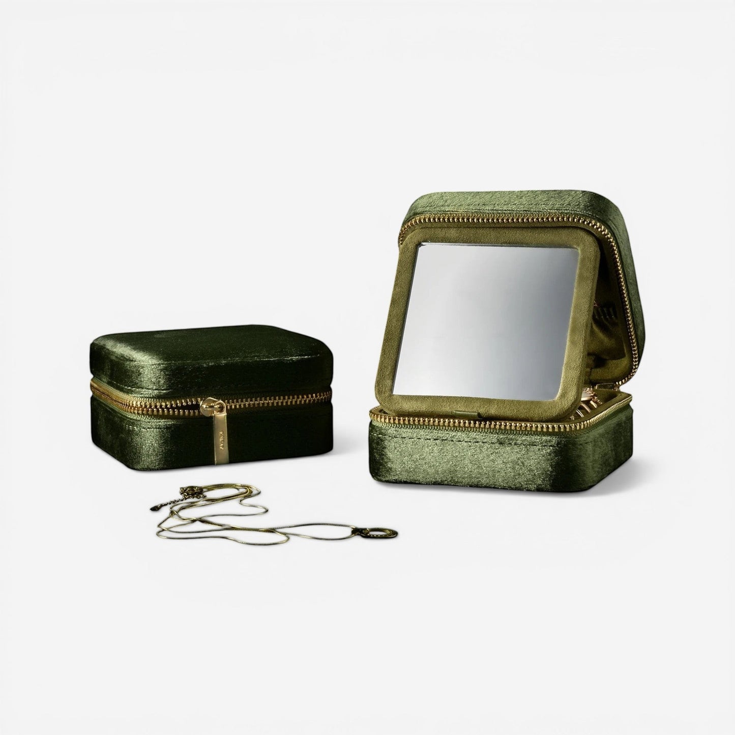 Petite boîte à bijoux de voyage en velours vert avec compartiments pratiques pour organiser vos bijoux en déplacement.