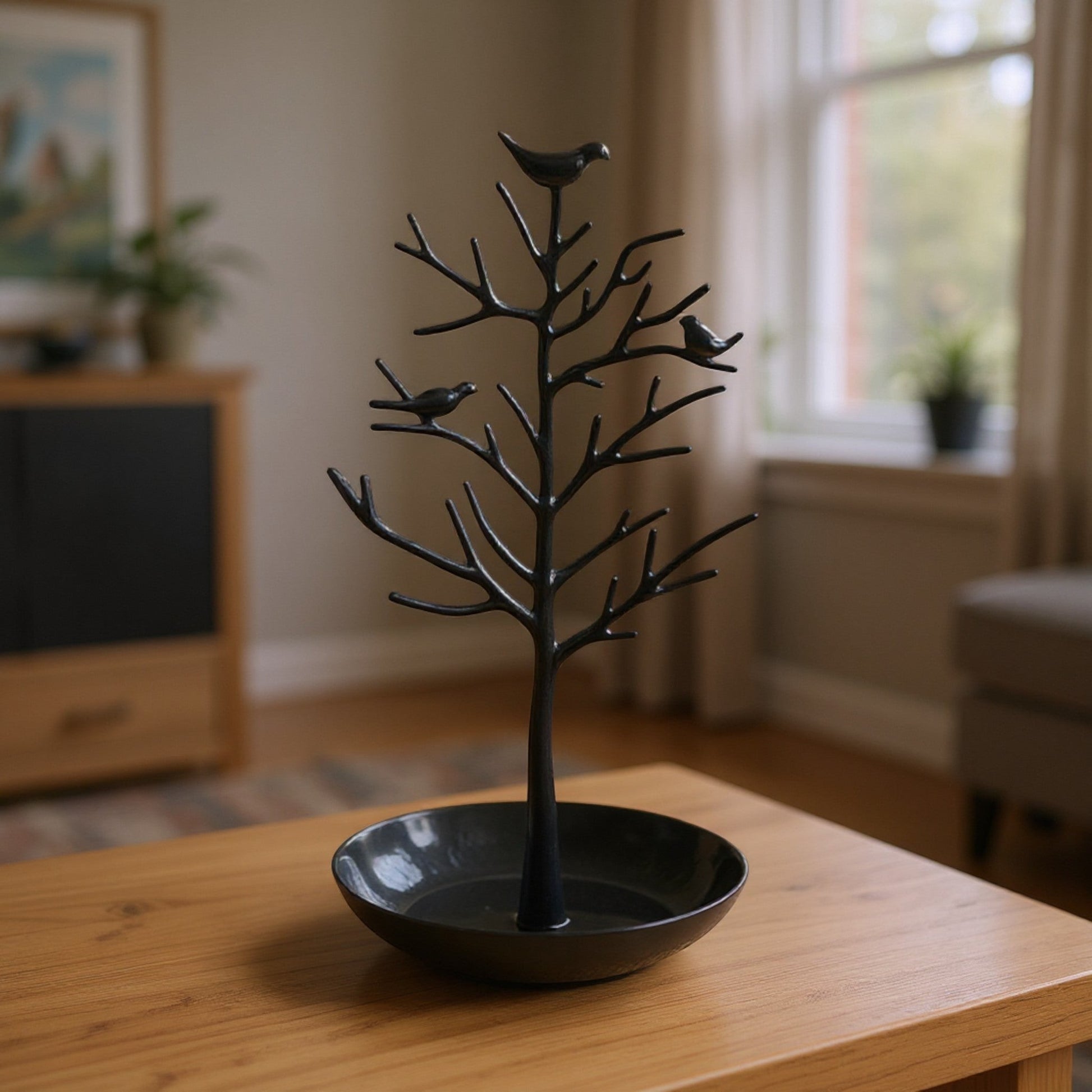 Présentoir à bijoux en alliage noir en forme d’arbre, élégant et décoratif, posé sur une table.