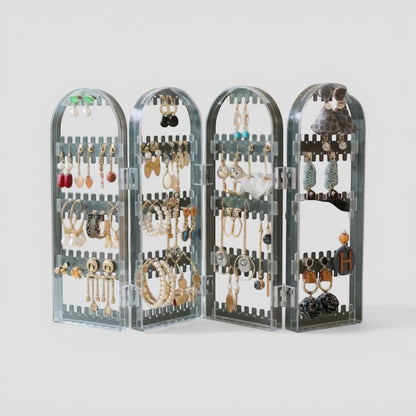 Présentoir à bijoux en acrylique transparent, avec plusieurs niveaux et compartiments pour organiser boucles d’oreilles et colliers.