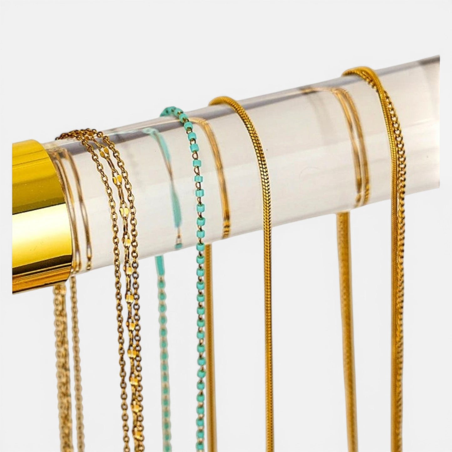 présentoir bijoux doré avec colliers suspendus pour une exposition élégante et organisée