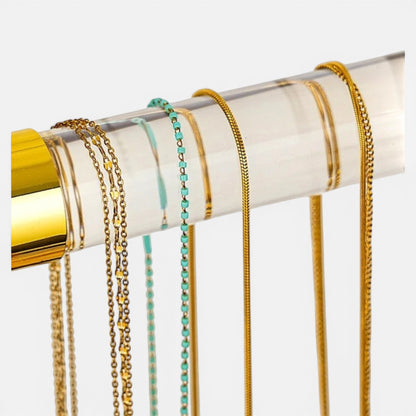 présentoir bijoux doré avec colliers suspendus pour une exposition élégante et organisée