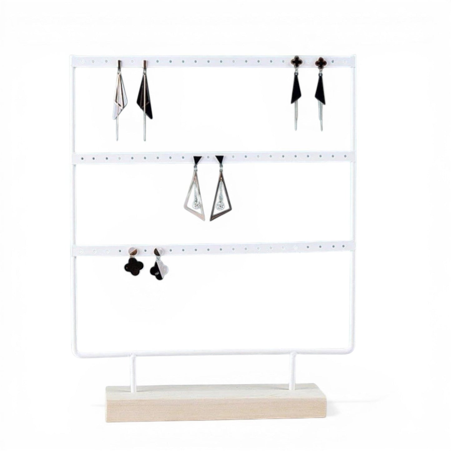Présentoir à boucles d’oreilles blanc avec bijoux suspendus et rangement organisé.