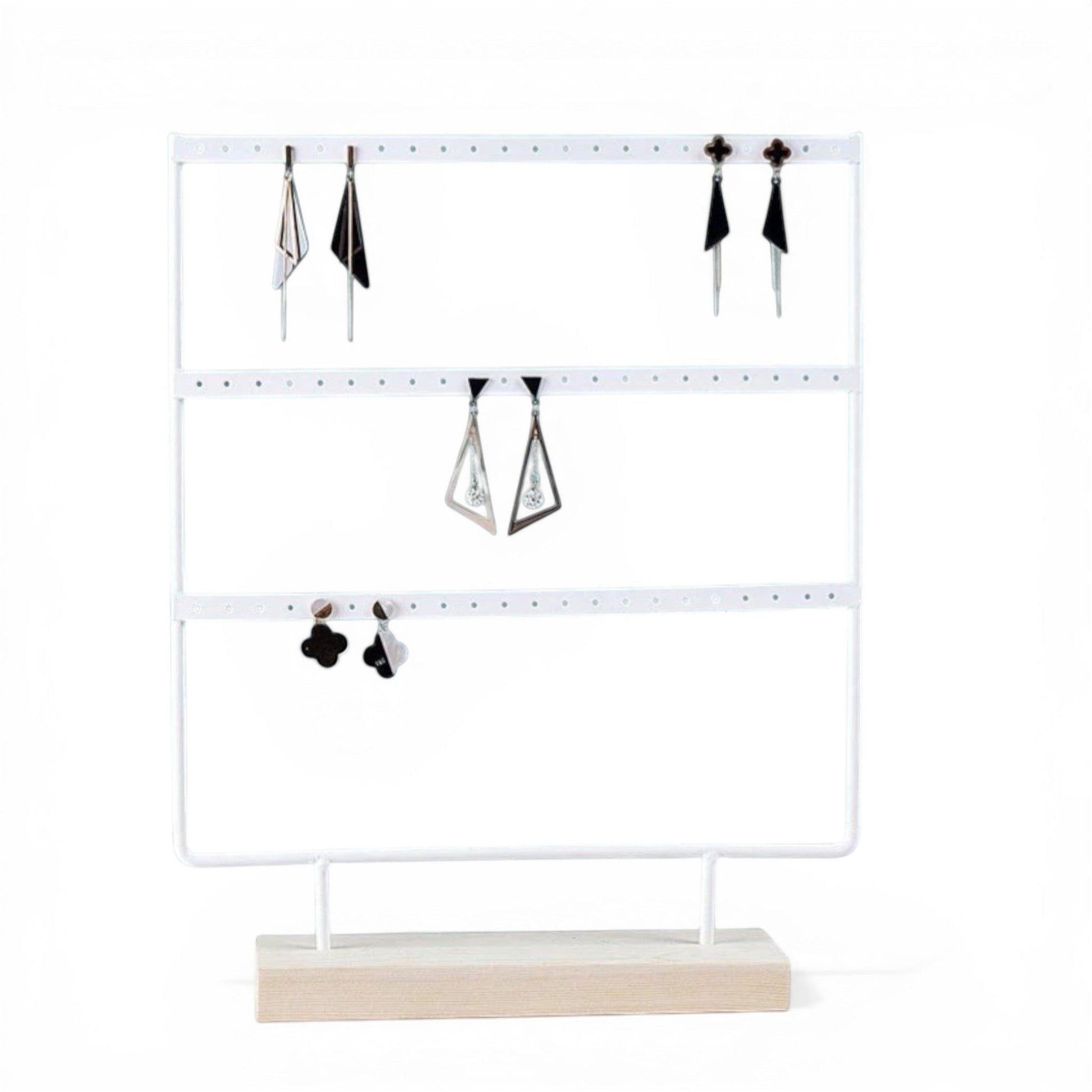 Présentoir à boucles d’oreilles blanc avec bijoux suspendus et rangement organisé.