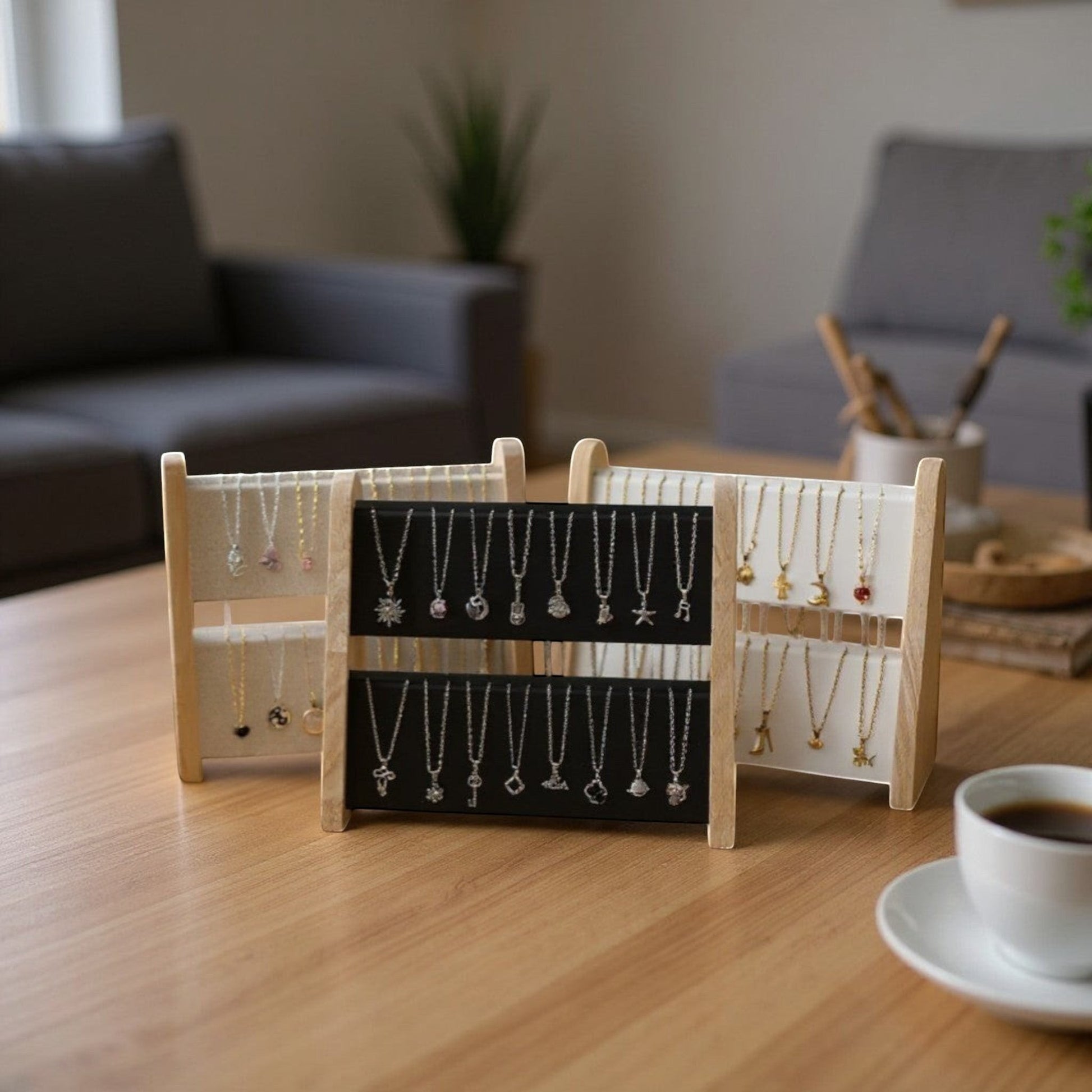 Présentoirs à colliers en bois et tissu, posés sur une table dans un intérieur moderne.