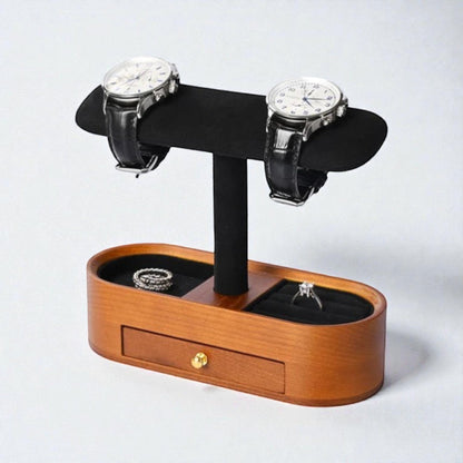 Présentoir pour montres noir avec tiroir intégré et compartiments pour bijoux.