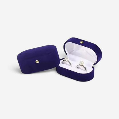 Boîte à bagues SecretGleam vintage en velours bleu profond avec deux bagues à perles, format voyage élégant