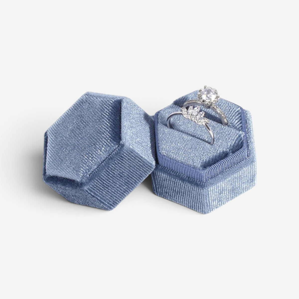 Boîte à bijoux hexagonale SecretGleam en velours bleu avec deux bagues de fiançailles argentées