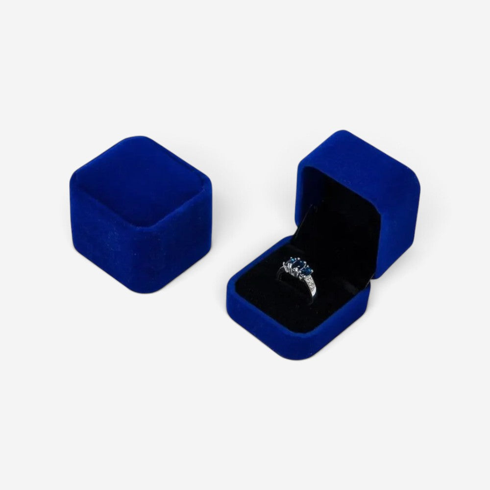 Boîte à bijoux carrée SecretGleam en velours bleu avec une bague à l'intérieur