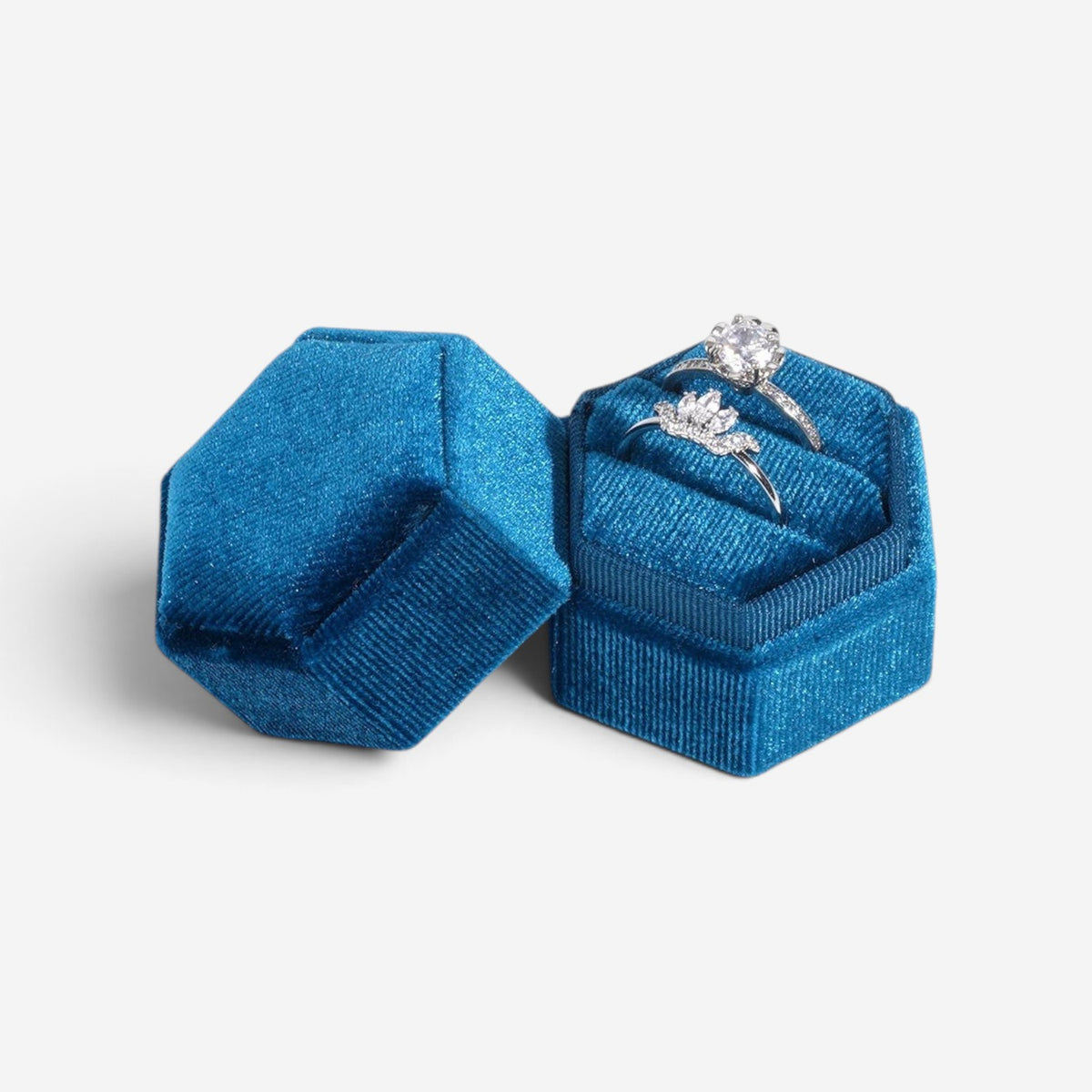Boîte à bijoux hexagonale SecretGleam en velours bleu avec deux bagues en argent pour fiançailles