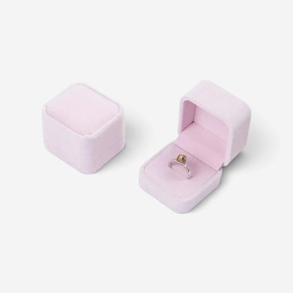 Boîte à bijoux carrée SecretGleam en velours rose pâle avec une bague à l'intérieur