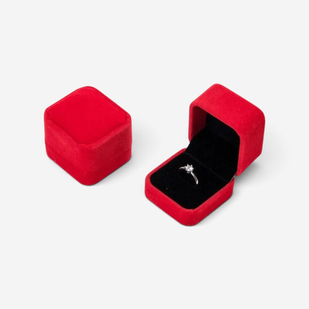Boîte à bijoux carrée SecretGleam en velours rouge avec une bague en argent à l'intérieur
