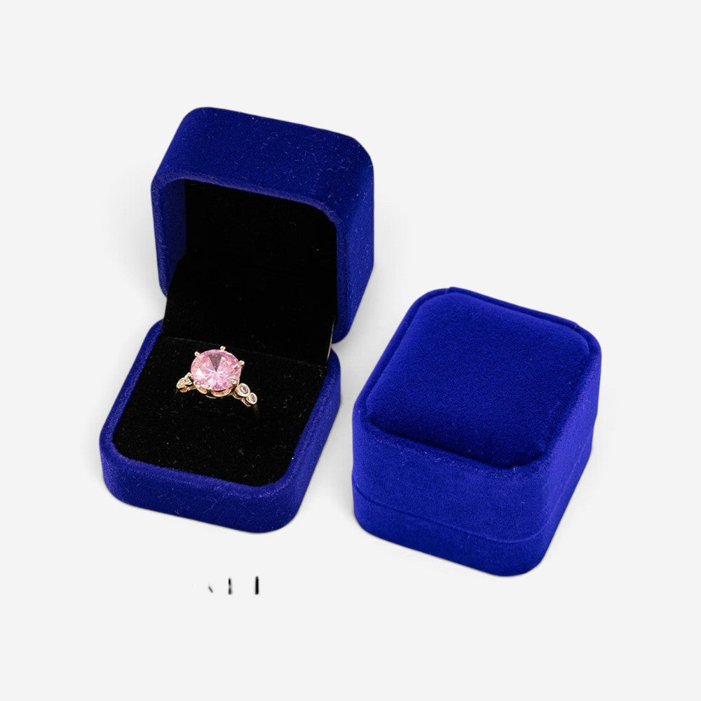 Mini boîte à bijoux SecretGleam en velours bleu contenant une bague avec une pierre rose, vue ouverte et fermée