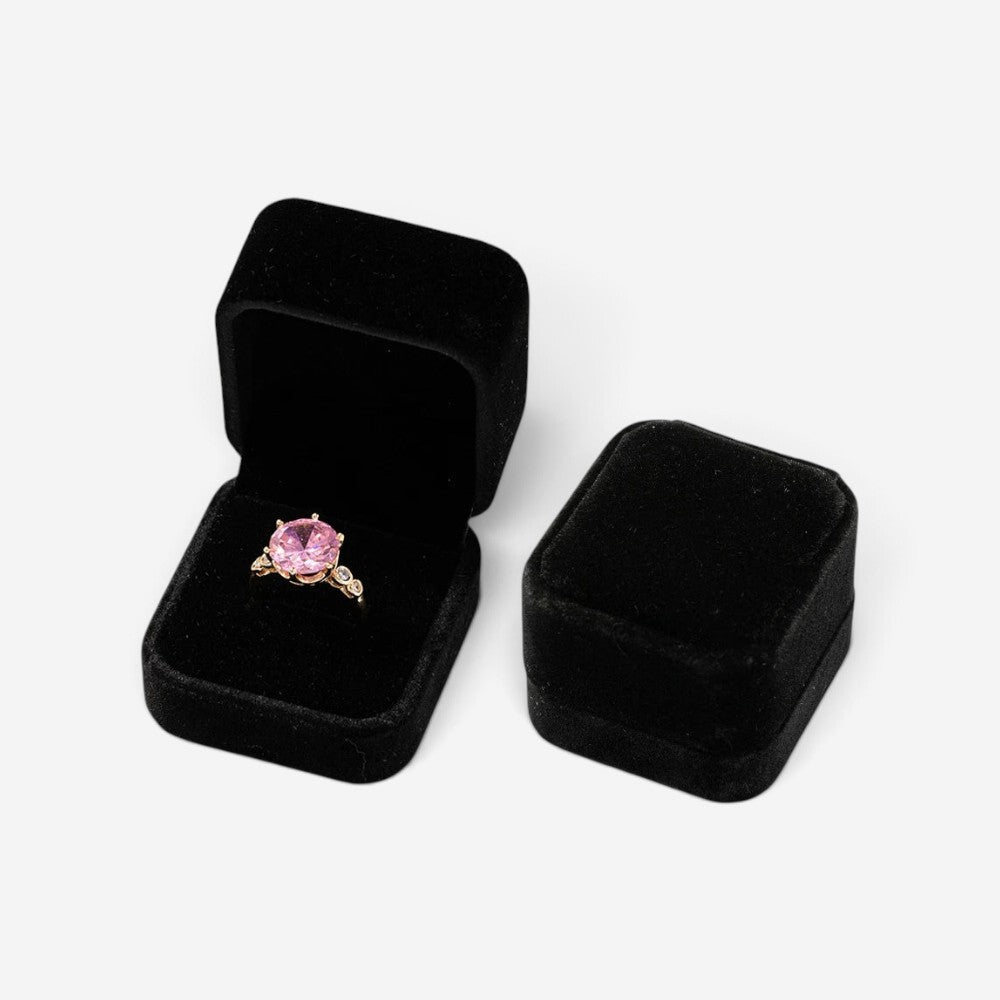 Mini boîte à bijoux SecretGleam en velours noir contenant une bague avec une pierre rose, vue ouverte et fermée
