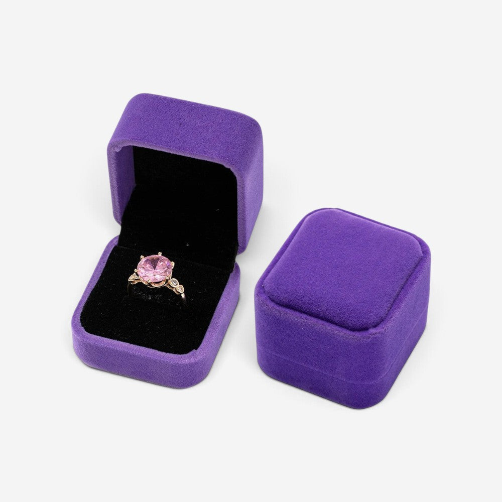 Mini boîte à bijoux SecretGleam en velours violet contenant une bague avec une pierre rose, vue ouverte et fermée